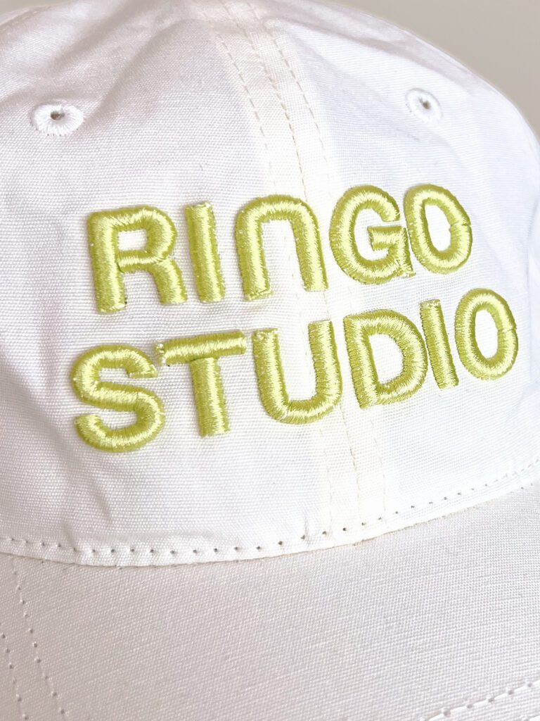 White coloured Ringo Studio cap with lime coloured embroidered Logo.