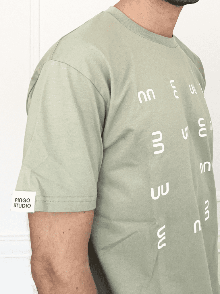 Man wearing Ringo Studio Pistachio cotton Tee with Ringo Studio monogram as textured pattern.